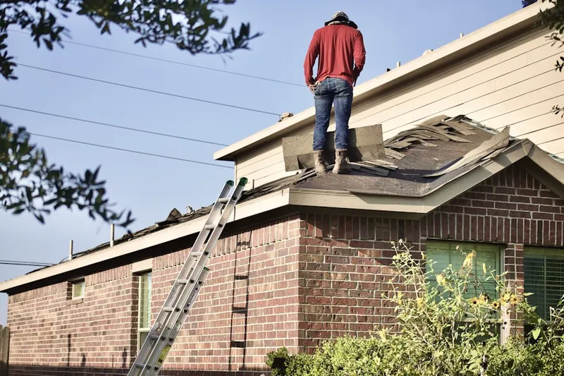 Professional roofer working on a residential roof in North Greenwich